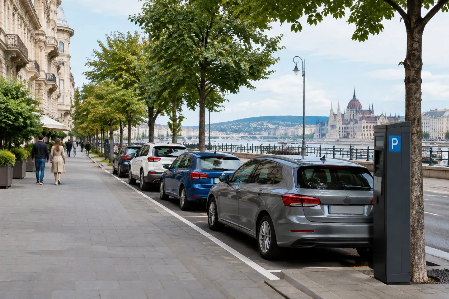Parked cars line a Budapest street on a calm weekend near historic city buildings.