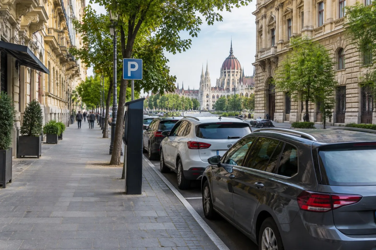 Cars parked along a street beside historic buildings in central Budapest.